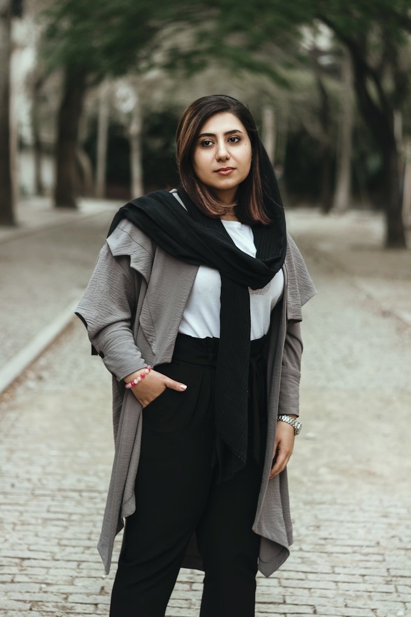 a woman standing on a brick road wearing a scarf